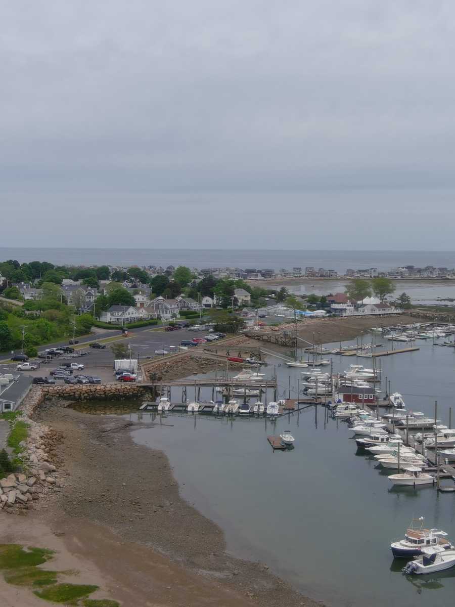 Aerial view of a small harbor town with wooden docks and moored boats on an overcast morning